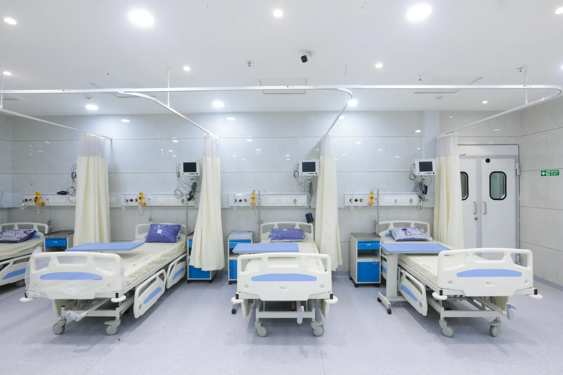 Row of patient beds in a ward with privacy curtains